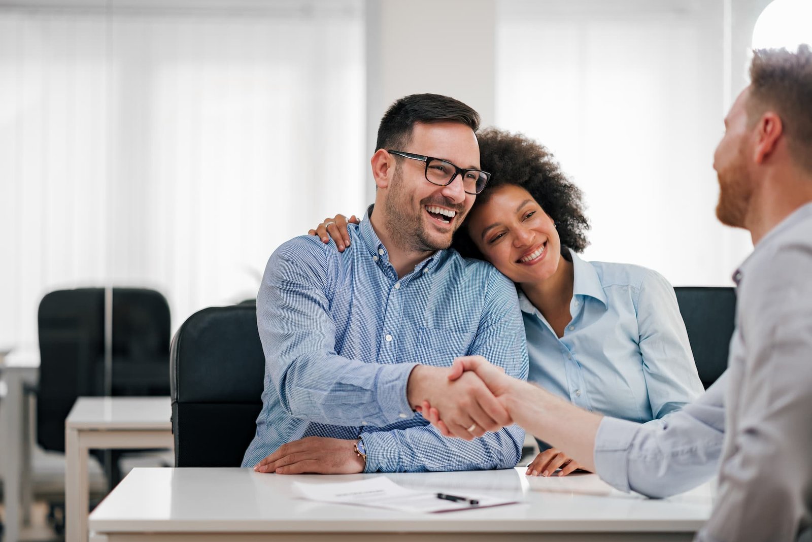 Pareja dando la mano a gestor inmobiliario